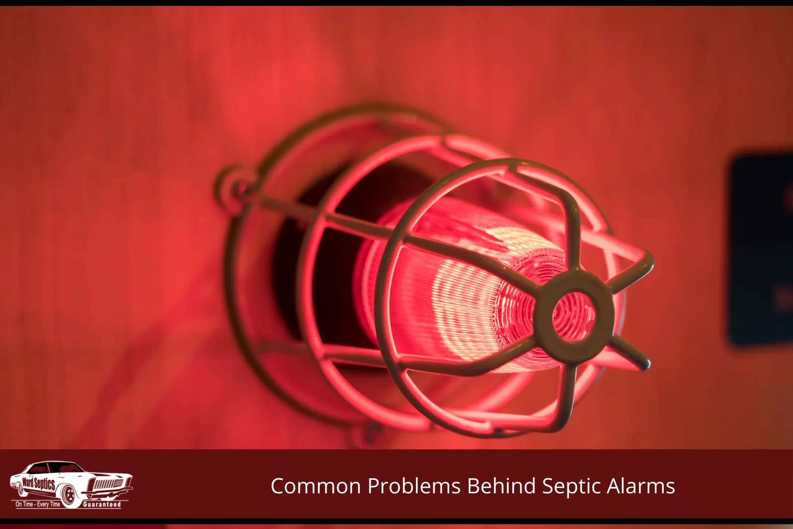 An illuminated red industrial alarm light protected by a white wire cage.