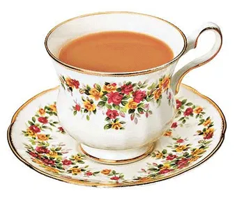A white floral teacup and matching saucer filled with milky tea.