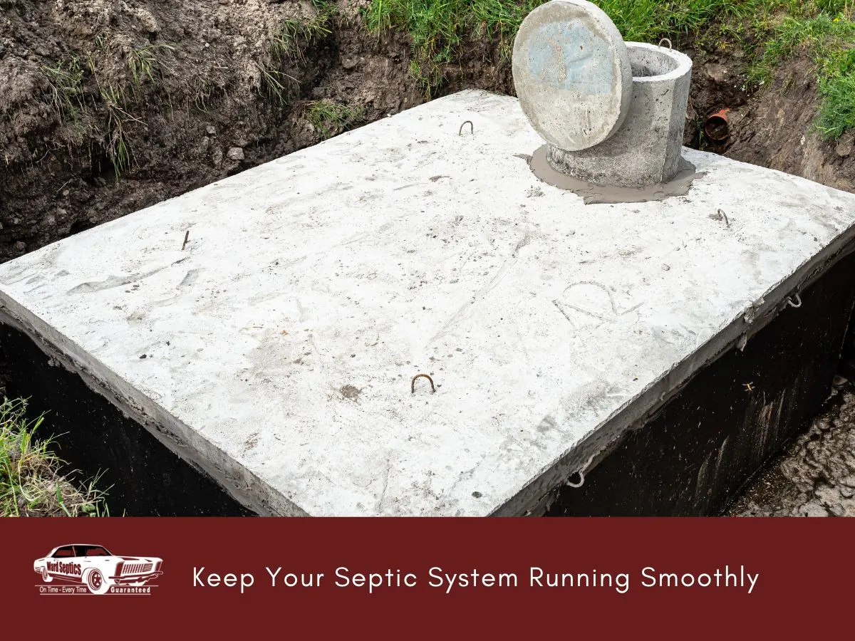 A concrete septic tank sits in an excavated pit with its riser and lid visible.