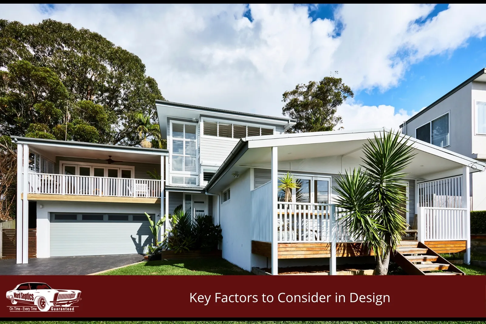 A multi-level contemporary house featuring white cladding, wooden balconies with white railings, a grey double garage door, and a green lawn under a bright blue sky.