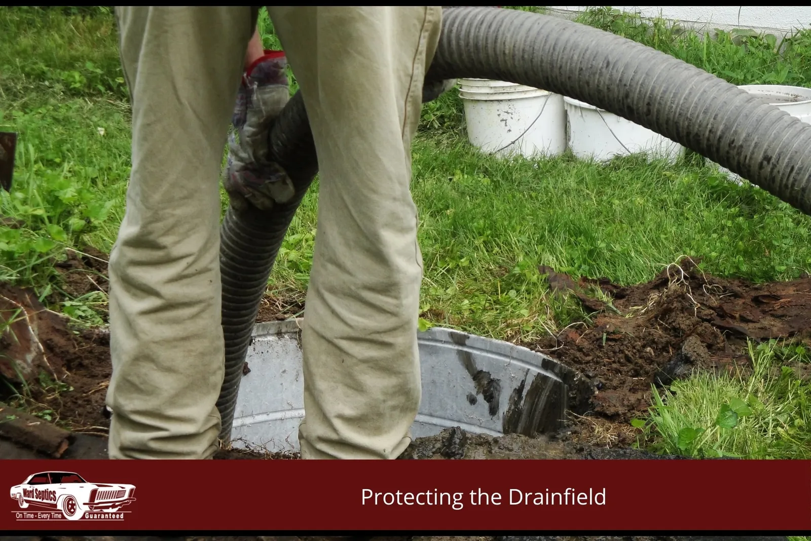 A technician's legs standing by an open underground septic tank.