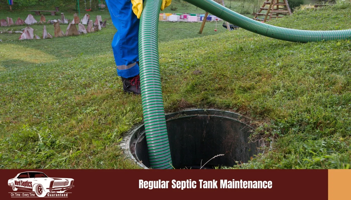 A worker in yellow gloves feeds a large, ribbed green suction hose into an open circular septic tank access port on a grassy lawn