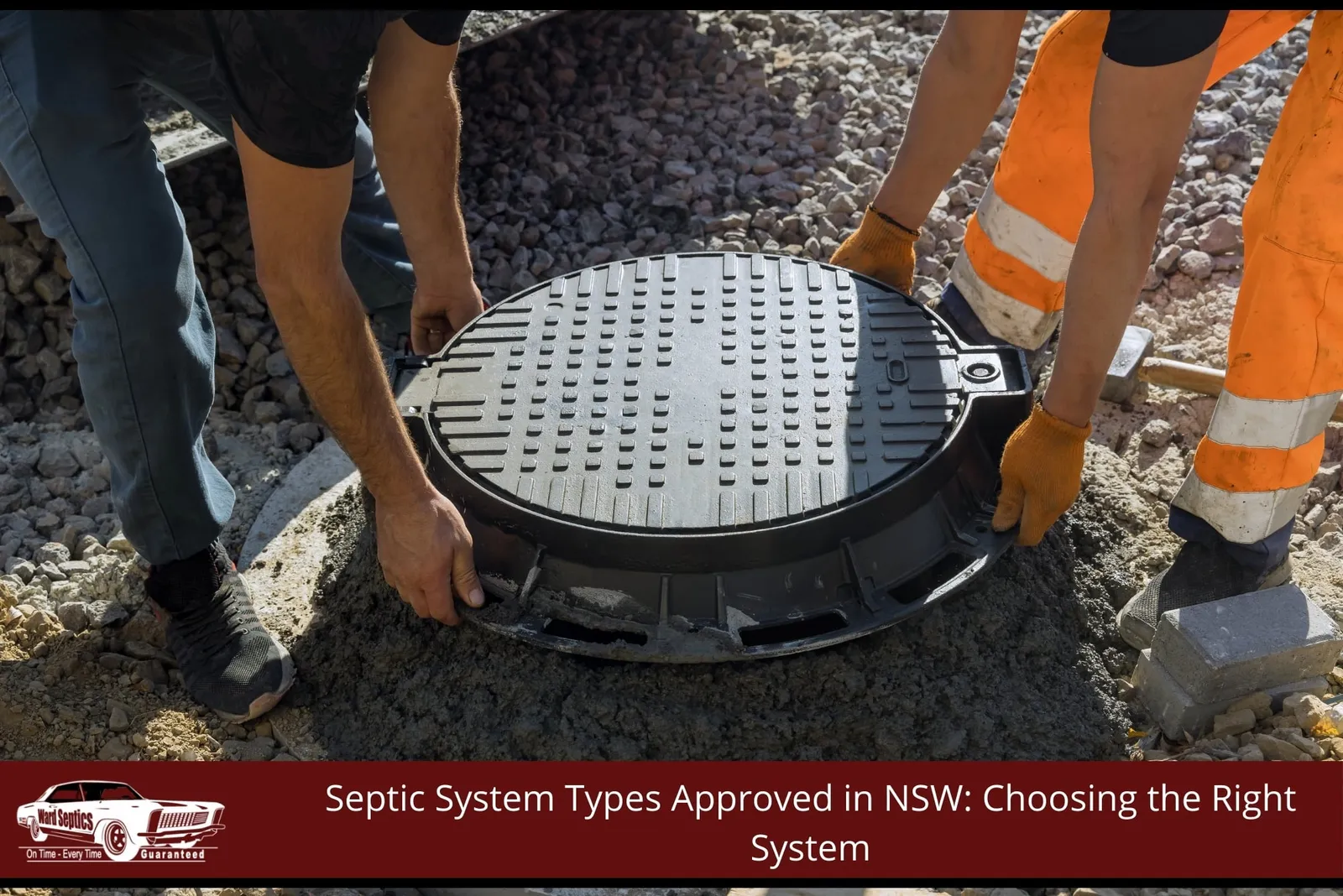 Two workers carefully lower a heavy black manhole cover onto a freshly poured ring of dark wet concrete.