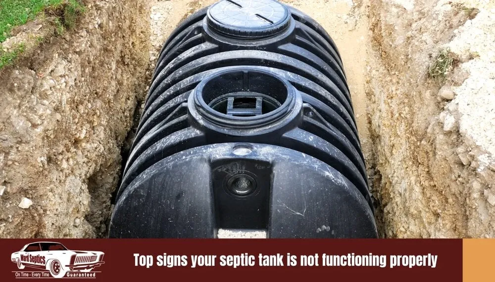 A black plastic septic tank sits in a freshly dug trench.