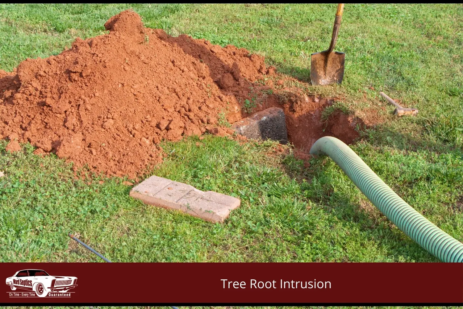 A green suction hose leads into an excavated hole in a grassy lawn next to a pile of red clay soil and a shovel.