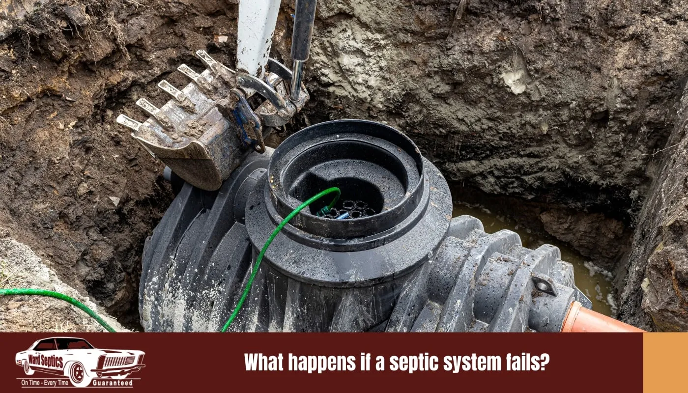 An excavator bucket hovering over a black plastic septic tank being installed in a muddy pit.