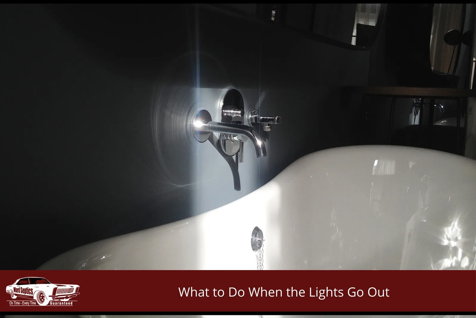 A white porcelain bathtub under a gleaming chrome wall-mounted faucet set against a dark grey wall.